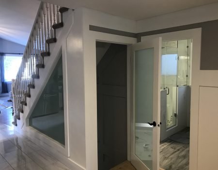 Glass door entrance leading to a finished basement bathroom in Stoney Creek renovation project